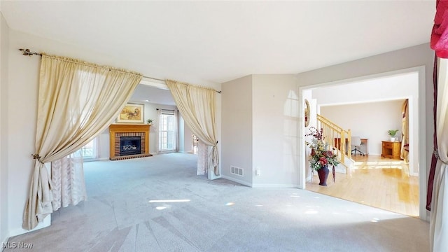 interior space featuring a brick fireplace and light colored carpet