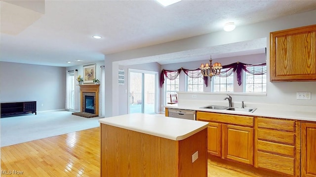 kitchen with pendant lighting, a fireplace, sink, a center island, and stainless steel dishwasher