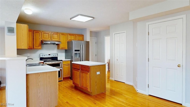 kitchen featuring sink, a kitchen island, light hardwood / wood-style floors, and appliances with stainless steel finishes