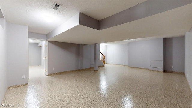 basement featuring a textured ceiling