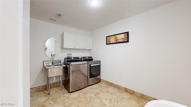 laundry room featuring separate washer and dryer, sink, and cabinets