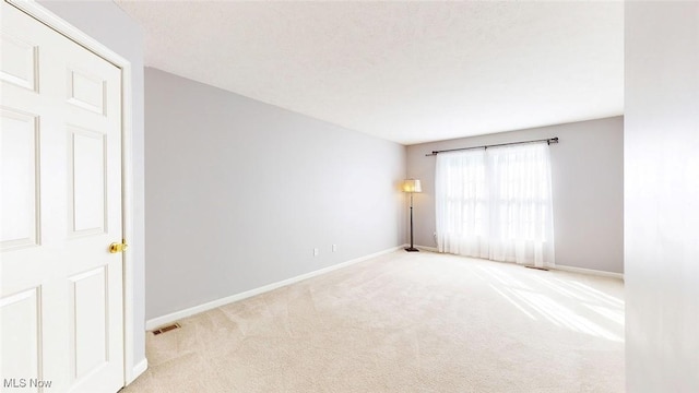 empty room with carpet flooring and a textured ceiling