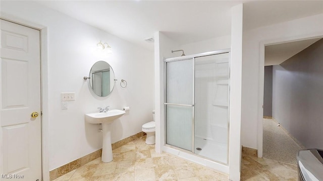 bathroom with a shower with door and toilet