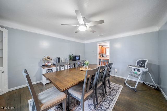 dining area with dark wood-type flooring and ceiling fan