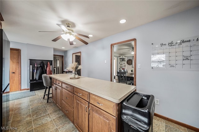 kitchen featuring ceiling fan and a kitchen bar