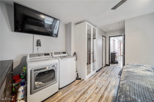 laundry area with washer and dryer and light wood-type flooring