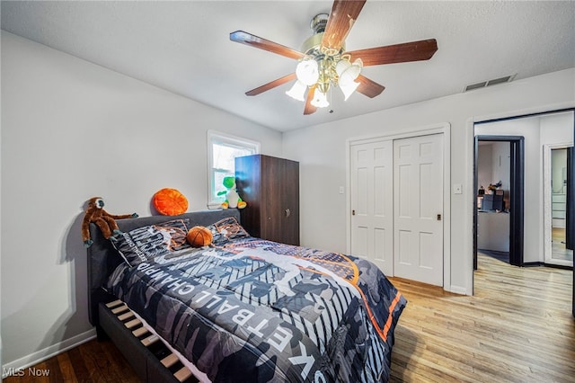 bedroom with light hardwood / wood-style flooring, a closet, and ceiling fan