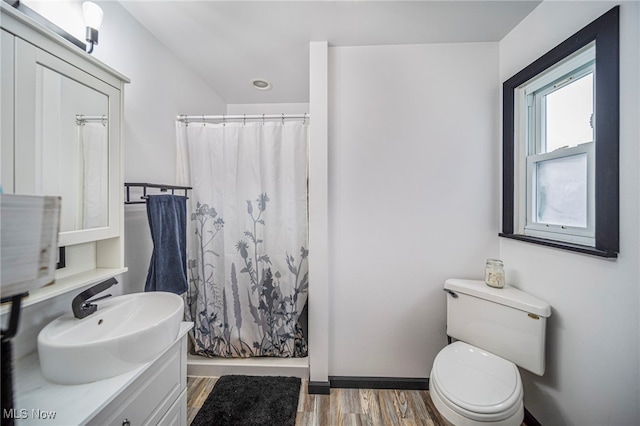 full bathroom with wood-type flooring, shower / tub combo, vanity, and toilet