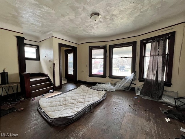 bedroom featuring a textured ceiling and dark hardwood / wood-style flooring