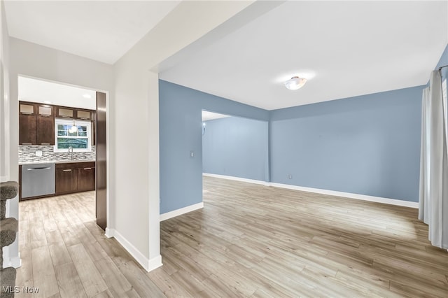 spare room featuring sink and light hardwood / wood-style floors