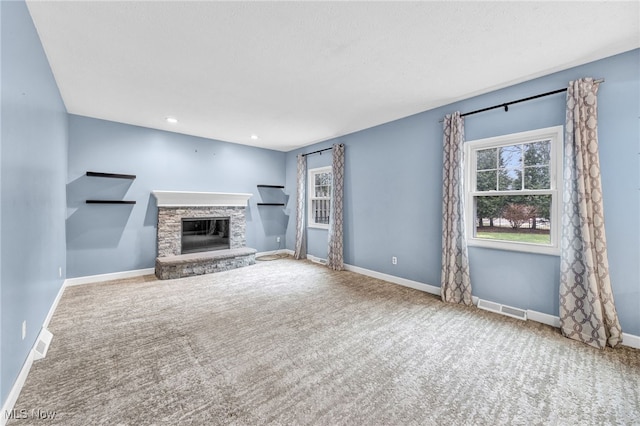 unfurnished living room with carpet and a fireplace