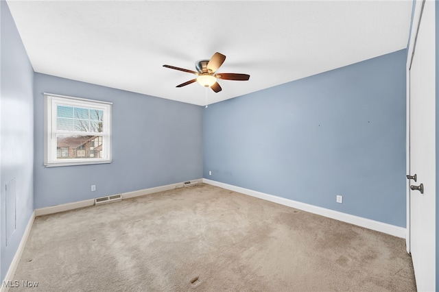 carpeted spare room with ceiling fan