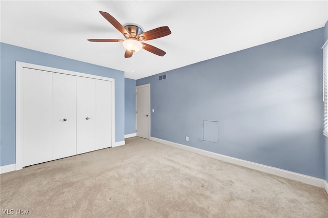 unfurnished bedroom with light colored carpet, ceiling fan, and a closet