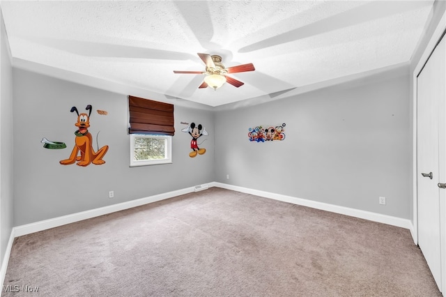 empty room with ceiling fan, carpet, and a textured ceiling