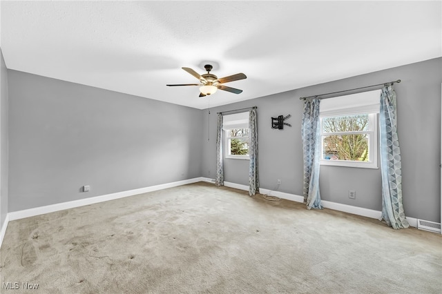 carpeted spare room featuring ceiling fan