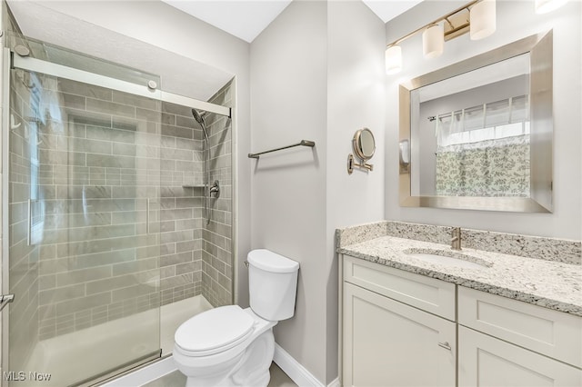 bathroom with vanity, toilet, and a shower with door