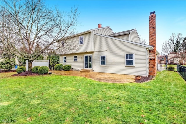 back of house featuring a lawn and a patio