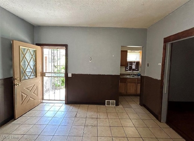 tiled foyer featuring sink and a textured ceiling