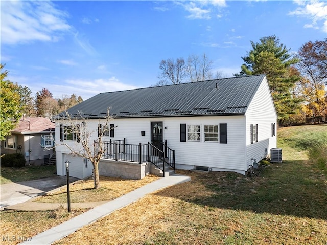 view of front facade featuring a garage, a front lawn, and central air condition unit