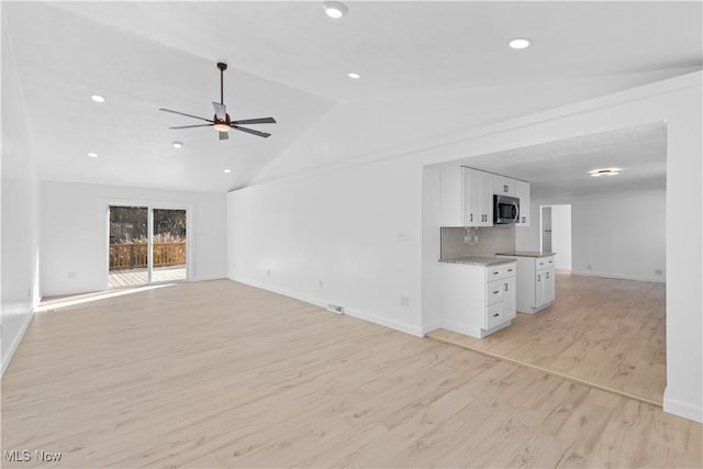 unfurnished living room with vaulted ceiling, ceiling fan, and light hardwood / wood-style floors