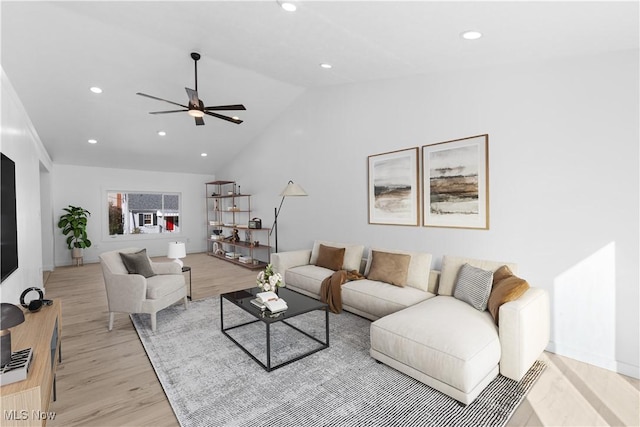 living room with ceiling fan, lofted ceiling, and light hardwood / wood-style floors