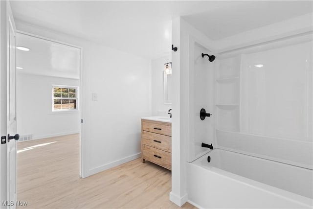 bathroom featuring wood-type flooring, bathing tub / shower combination, and vanity