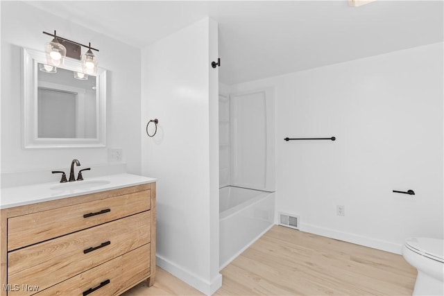 full bathroom featuring bathtub / shower combination, vanity, toilet, and hardwood / wood-style floors