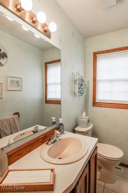 bathroom featuring plenty of natural light, toilet, tile patterned flooring, and vanity