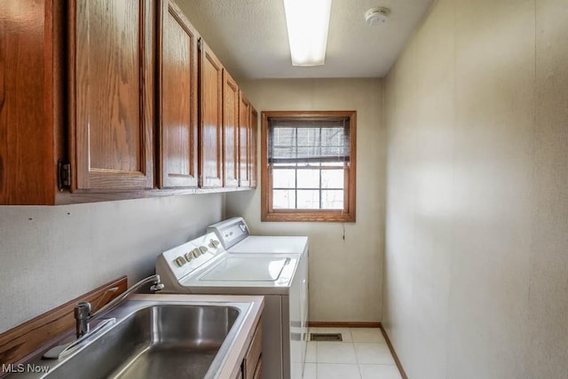 clothes washing area with cabinets, sink, and independent washer and dryer