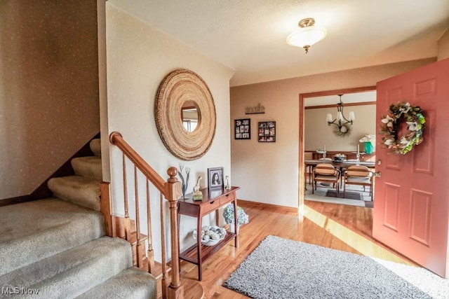 entrance foyer with hardwood / wood-style floors and a notable chandelier