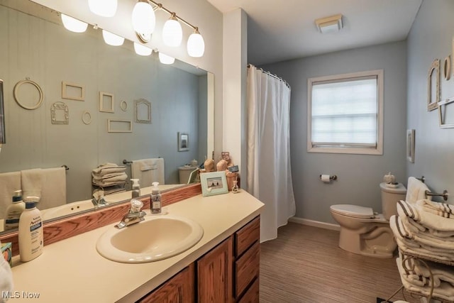 bathroom with vanity, toilet, and wood-type flooring