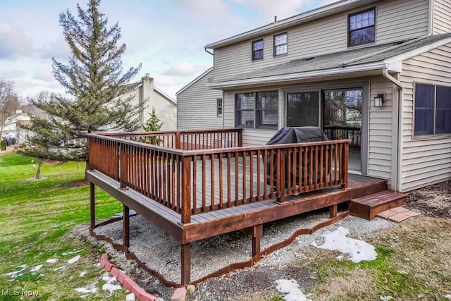 rear view of property featuring a wooden deck and a yard