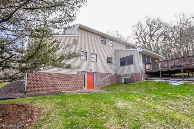 rear view of house featuring a wooden deck, a yard, and central AC unit