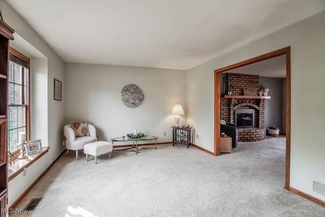 sitting room featuring a brick fireplace and light carpet