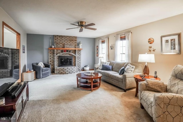 carpeted living room featuring a brick fireplace and ceiling fan