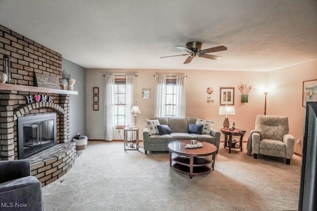 carpeted living room featuring a brick fireplace and ceiling fan