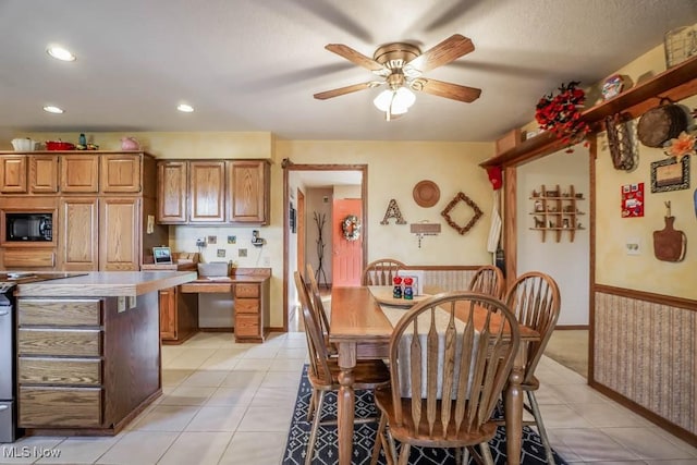 tiled dining space featuring ceiling fan