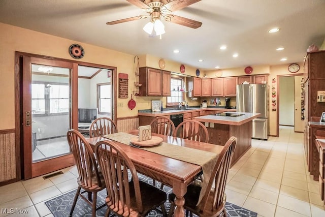 dining area featuring sink, light tile patterned floors, and ceiling fan