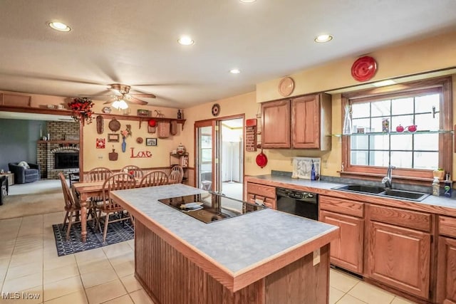 kitchen with a kitchen island, a fireplace, sink, ceiling fan, and black appliances