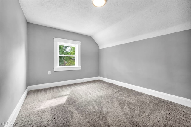 bonus room featuring carpet floors, vaulted ceiling, and a textured ceiling