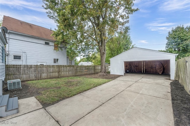 garage with central AC unit and a lawn