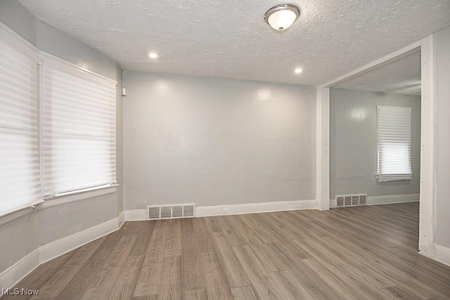 spare room with hardwood / wood-style flooring and a textured ceiling