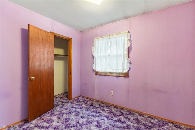 unfurnished bedroom with a closet and light carpet