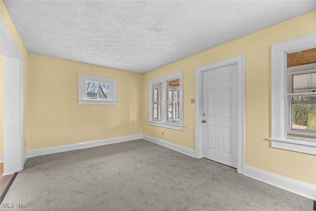 carpeted spare room with a textured ceiling