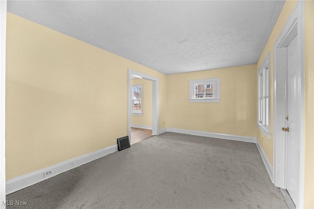 unfurnished room with carpet floors and a textured ceiling