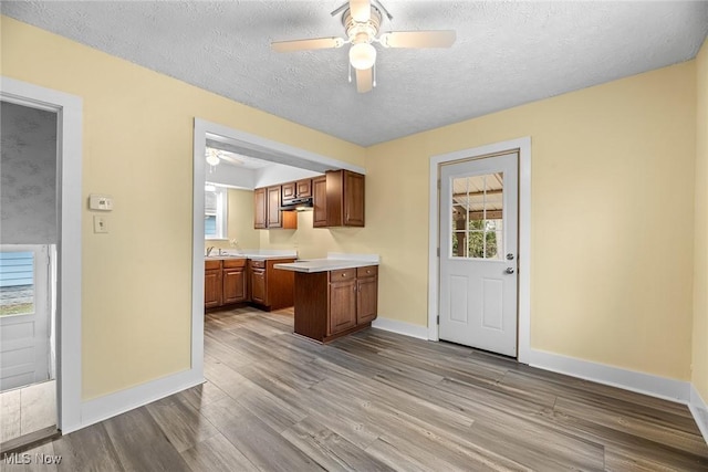 kitchen with ceiling fan, light hardwood / wood-style floors, and a textured ceiling