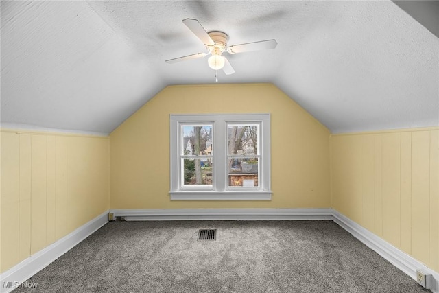 bonus room with lofted ceiling, ceiling fan, a textured ceiling, and carpet flooring