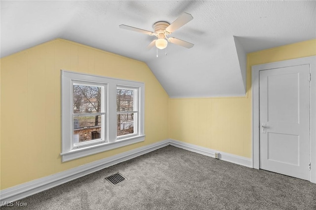 bonus room with vaulted ceiling, carpet flooring, a textured ceiling, and ceiling fan