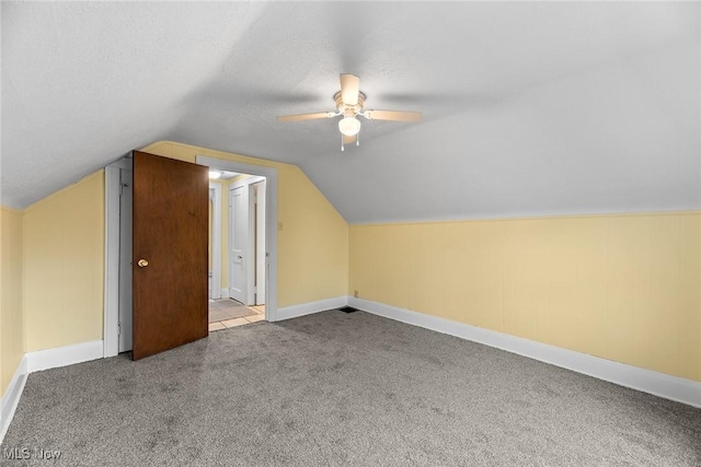 additional living space featuring lofted ceiling, ceiling fan, light colored carpet, and a textured ceiling