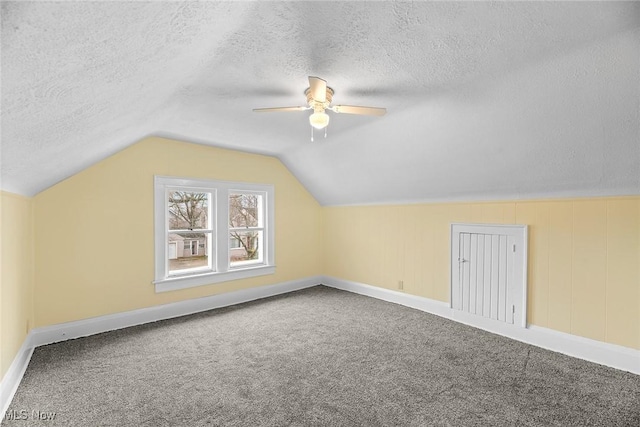 bonus room featuring ceiling fan, carpet floors, a textured ceiling, and vaulted ceiling